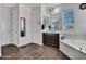 Well-lit bathroom featuring a soaking tub, vanity with mirror, and neutral color palette at 18225 W Mackenzie Dr, Goodyear, AZ 85395