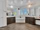 Spacious bathroom featuring dual vanities, a soaking tub, tile flooring and ample natural light at 18225 W Mackenzie Dr, Goodyear, AZ 85395