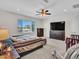 Bedroom with a large window, carpet flooring, ceiling fan, and a built-in entertainment center at 18225 W Mackenzie Dr, Goodyear, AZ 85395