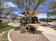 Well-maintained community playground with a shaded play structure and surrounding landscape at 18225 W Mackenzie Dr, Goodyear, AZ 85395