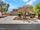 Well-manicured front yard with mature trees, leading to a two-story home with an attached garage at 18225 W Mackenzie Dr, Goodyear, AZ 85395