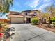 Two-story home with a large driveway and three-car garage, showcasing its well-maintained landscaping and exterior design at 18225 W Mackenzie Dr, Goodyear, AZ 85395