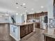 A kitchen features dark wood cabinets, granite countertops, stainless appliances, and a center island at 18225 W Mackenzie Dr, Goodyear, AZ 85395