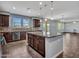 A kitchen features dark wood cabinets, granite countertops, a center island and stainless appliances at 18225 W Mackenzie Dr, Goodyear, AZ 85395