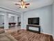 Spacious living room showcasing hardwood flooring, a flat screen TV, and adjacent recreational area at 18225 W Mackenzie Dr, Goodyear, AZ 85395