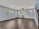 Bright living room with neutral walls, tile floors, large windows, and a staircase at 18225 W Mackenzie Dr, Goodyear, AZ 85395