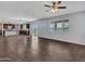 Expansive living room featuring neutral toned tile flooring, a ceiling fan, and open to the kitchen at 18225 W Mackenzie Dr, Goodyear, AZ 85395