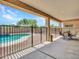 A covered patio with an outdoor dining set and view of the fenced pool at 18225 W Mackenzie Dr, Goodyear, AZ 85395