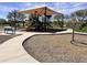 Community playground featuring a large shaded play structure and seating areas at 18225 W Mackenzie Dr, Goodyear, AZ 85395