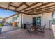 This covered patio contains a round glass table and four cushioned chairs, and a barbecue grill at 1830 N 87Th Ter, Scottsdale, AZ 85257