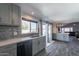 Bright kitchen with gray cabinets, stainless steel appliances, and view of the backyard at 1830 N 87Th Ter, Scottsdale, AZ 85257