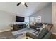 Bright living room featuring a large gray sectional, wood-look floors, and a modern ceiling fan for comfort at 1830 N 87Th Ter, Scottsdale, AZ 85257