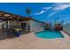 This backyard features a fenced-in pool and a covered patio with a palm tree in a blue pot at 1830 N 87Th Ter, Scottsdale, AZ 85257