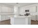 Modern kitchen with white cabinetry, a marble countertop island with a sink, and stainless steel appliances at 18848 E Bruno Dr, Gold Canyon, AZ 85118