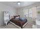 Cozy bedroom featuring a ceiling fan, plush bedding, a full-length mirror, and a window at 1896 S Porter St, Gilbert, AZ 85295