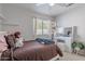 Comfortable bedroom includes a window, ceiling fan, and a charming vanity area with coordinated decor at 1896 S Porter St, Gilbert, AZ 85295