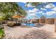 Resort-style backyard featuring a sparkling pool, waterfall feature, umbrellas, and lush landscaping at 1938 N 67Th St, Mesa, AZ 85205