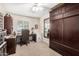 Bedroom with a wooden desk, chair, mini-fridge, large wooden wardrobe, and a well-lit window at 1938 N 67Th St, Mesa, AZ 85205