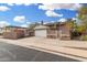 Side view of a one-story home with a brick wall, lush bougainvillea and two-car garage at 1938 N 67Th St, Mesa, AZ 85205