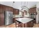 A spacious kitchen with dark wood cabinets, stainless steel appliances, and a large island with a speckled countertop at 1938 N 67Th St, Mesa, AZ 85205