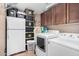 Functional laundry room with washer, dryer, refrigerator, storage bins, and ample cabinet space at 1938 N 67Th St, Mesa, AZ 85205