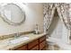 Bright bathroom with a large mirror, granite countertop, and a shower-tub combo with floral accents at 19927 N 108Th Ln, Sun City, AZ 85373