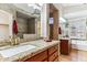 Bathroom featuring granite counters, wood cabinets, a walk-in shower and soaking tub at 19927 N 108Th Ln, Sun City, AZ 85373