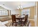 Elegant dining room featuring a wooden table, six chairs, chandelier, and natural light from shuttered windows at 19927 N 108Th Ln, Sun City, AZ 85373