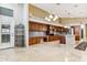 Gourmet kitchen featuring stainless steel appliances, custom wood cabinets, an island, and tile flooring at 19927 N 108Th Ln, Sun City, AZ 85373