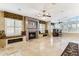 Spacious living room with a modern fireplace, custom window seats, and elegant tile flooring at 19927 N 108Th Ln, Sun City, AZ 85373