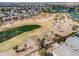 Beautiful aerial view of golf course featuring mature trees, lush green grass, water features, and gorgeous community at 22050 N Balboa Dr, Maricopa, AZ 85138