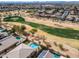 Wonderful aerial view of golf course featuring mature trees, lush green grass, and gorgeous community in background at 22050 N Balboa Dr, Maricopa, AZ 85138