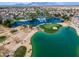 Breathtaking aerial view of golf course community featuring lush landscaping, a lake with water features, and mature trees at 22050 N Balboa Dr, Maricopa, AZ 85138