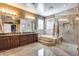 Well-lit bathroom featuring dual sinks, walk-in shower and separate bathtub at 22050 N Balboa Dr, Maricopa, AZ 85138