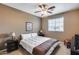 Comfortable bedroom with neutral-toned walls, ceiling fan, and a large window for bright, natural light at 22050 N Balboa Dr, Maricopa, AZ 85138