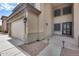 Beige two-story home featuring a two-car garage and decorative black front door at 22050 N Balboa Dr, Maricopa, AZ 85138