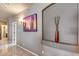 Hallway with tiled floors, sconce lighting, decorative vase, and a view into another room at 22050 N Balboa Dr, Maricopa, AZ 85138