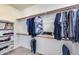 Spacious walk-in closet features carpet, built-in shelving, and hanging racks at 22050 N Balboa Dr, Maricopa, AZ 85138