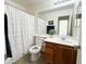 Bright bathroom featuring a shower-tub combination, single sink vanity, decorative mirror, and neutral tile floors at 2344 W Barwick Dr, Phoenix, AZ 85085