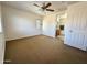 Bedroom features ceiling fan, nearby bathroom, and large windows overlooking the neighborhood at 2344 W Barwick Dr, Phoenix, AZ 85085