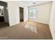 A bright bedroom featuring carpet floors, natural light, and a view to the walk-in closet and bathroom at 2344 W Barwick Dr, Phoenix, AZ 85085