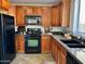 Kitchen with dark wood cabinetry, granite countertops, and black appliances at 2344 W Barwick Dr, Phoenix, AZ 85085