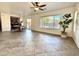 Open living room with tile flooring, fan, large window, and access to the dining area at 2344 W Barwick Dr, Phoenix, AZ 85085