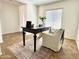 Bright home office featuring a dark wood desk, area rug, and a comfortable armchair at 2344 W Barwick Dr, Phoenix, AZ 85085