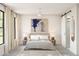 Light and airy main bedroom featuring neutral decor, a ceiling fan, and a sliding barn door to the en-suite at 2400 W Los Arboles Pl, Chandler, AZ 85224