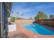 Backyard featuring a blue in-ground pool surrounded by a red concrete deck with desert landscaping at 2507 E Golden St, Mesa, AZ 85213