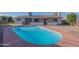 Backyard featuring a blue in-ground pool surrounded by a red concrete deck and landscaping at 2507 E Golden St, Mesa, AZ 85213