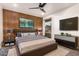 Stylish bedroom featuring a wood accent wall, modern furniture, and a mounted TV at 2920 S Bala Dr, Tempe, AZ 85282