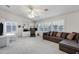 Living room features built-in shelving with desk, ceiling fan and large sectional couch for cozy living at 3017 S Mesita --, Mesa, AZ 85212