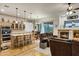 Open-concept living space with a kitchen island, a stone fireplace, and lots of natural light at 3017 S Mesita --, Mesa, AZ 85212